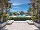 Framed view of the community pool through beautiful pergola and lush tropical greenery at 340 Gulf Of Mexico Dr # 124, Longboat Key, FL 34228