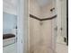 The tiled shower features a black accent stripe and updated fixtures at 340 Gulf Of Mexico Dr # 124, Longboat Key, FL 34228