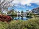Picturesque waterfront community with a serene pond reflecting luxury condos and vibrant tropical foliage at 340 Gulf Of Mexico Dr # 124, Longboat Key, FL 34228