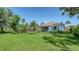 Expansive backyard featuring lush green lawn, tropical landscaping, and a screened-in patio area at 3847 Little Country Rd, Parrish, FL 34219