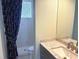 This bathroom has a shower and gray vanity with a sink, and is adjacent to another room at 3847 Little Country Rd, Parrish, FL 34219