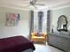 The bedroom features a comfortable sitting area with a yellow settee and brightly patterned curtains at 3847 Little Country Rd, Parrish, FL 34219
