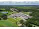 Aerial view of community clubhouse overlooking a golf course, surrounded by trees and nearby homes at 3847 Little Country Rd, Parrish, FL 34219