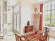 Elegant dining room with a glass-topped table, chandelier, and large windows for natural light at 3847 Little Country Rd, Parrish, FL 34219