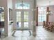 Bright foyer with tiled floor, double doors, and decorative columns, leading to the dining area at 3847 Little Country Rd, Parrish, FL 34219