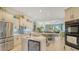 Open-concept kitchen with stainless steel appliances, wine fridge, marble countertops, and tile flooring at 3847 Little Country Rd, Parrish, FL 34219
