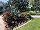 Lush landscaping featuring colorful flowers and mature plants in front of a well-maintained home at 3847 Little Country Rd, Parrish, FL 34219