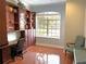 Home office featuring built-in shelving, hardwood floors, and a large window with natural light at 3847 Little Country Rd, Parrish, FL 34219