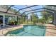 Beautiful pool with brick surround, fountain, and lounge seating under screened enclosure at 3847 Little Country Rd, Parrish, FL 34219