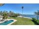 Expansive backyard featuring a lush lawn, a sparkling pool, and scenic waterfront views, creating a private oasis at 404 S Shore Dr, Sarasota, FL 34234