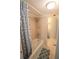 Cozy bathroom featuring a shower and tub, with a decorative curtain, tiled walls, and matching floor mats at 4206 Heron Way # B305, Bradenton, FL 34205