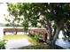 Scenic view of a wooden dock extending over the water, framed by a mature tree with lush foliage at 4206 Heron Way # B305, Bradenton, FL 34205