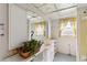 Bright bathroom featuring blue-patterned floors, yellow-trimmed windows, and a decorative plant at 440 Redwood Rd, Venice, FL 34293