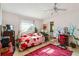 Bright bedroom featuring a comfortable bed, a ceiling fan, and natural light from the window at 440 Redwood Rd, Venice, FL 34293
