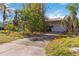 A single-story home with a driveway, tropical landscaping, and a one-car garage at 440 Redwood Rd, Venice, FL 34293