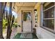 This image shows the entrance of a home with bamboo stalks and an exterior light fixture at 440 Redwood Rd, Venice, FL 34293