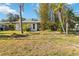 Modest home with a simple lawn, mature trees, and minimal landscaping at 440 Redwood Rd, Venice, FL 34293