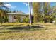 A simple home featuring minimal landscaping, a modest lawn, and mature shade trees at 440 Redwood Rd, Venice, FL 34293