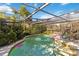 Screened pool area with a clear enclosure, surrounded by lush greenery and colorful pool floats at 440 Redwood Rd, Venice, FL 34293
