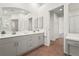 Bathroom with double vanity, and a large mirror and adjacent dressing table at 4449 Greenfield Ave, Sarasota, FL 34233