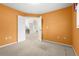 Bright bedroom features orange walls, neutral carpet, and an open doorway at 4449 Greenfield Ave, Sarasota, FL 34233