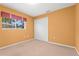 Bedroom featuring neutral carpeting, bright orange walls and a closet at 4449 Greenfield Ave, Sarasota, FL 34233