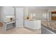 Kitchen island and desk area boasts granite countertops, white cabinets, and bright lighting at 4449 Greenfield Ave, Sarasota, FL 34233