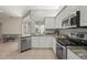 Bright kitchen features granite countertops, stainless steel appliances, and open access to living area at 4449 Greenfield Ave, Sarasota, FL 34233