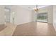 Open-concept living area with tile floors and sliding glass doors leading to the outdoor screened in pool at 4449 Greenfield Ave, Sarasota, FL 34233