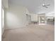 Open-concept living area with neutral tones, carpet, leading to a patio with an outdoor dining area and pool at 4449 Greenfield Ave, Sarasota, FL 34233