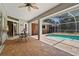 Screened patio with a private pool, ceiling fan, and brick flooring at 4449 Greenfield Ave, Sarasota, FL 34233