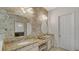 Elegant bathroom featuring double vanities, granite countertops, and decorative lighting fixtures at 5715 Inspiration Ter, Bradenton, FL 34210