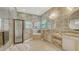 Luxury bathroom with a walk-in shower, soaking tub, and dual vanities with designer finishes and lots of light at 5715 Inspiration Ter, Bradenton, FL 34210