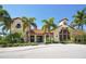 Beautiful community clubhouse with lush landscaping, a terracotta roof, and neutral stucco at 5715 Inspiration Ter, Bradenton, FL 34210