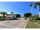 A gated community entrance with a guard house, brick drive, colorful flowers and well maintained landscaping with palm trees at 5715 Inspiration Ter, Bradenton, FL 34210