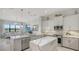 Modern kitchen open to the living room with an eat-in breakfast bar, marble countertops, and stainless steel appliances at 5715 Inspiration Ter, Bradenton, FL 34210