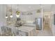 Modern kitchen featuring white cabinetry, marble countertops, stainless steel appliances, and an eat-in breakfast bar at 5715 Inspiration Ter, Bradenton, FL 34210
