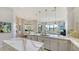 Modern kitchen with marble countertops and stainless steel appliances, open to the dining and living spaces at 5715 Inspiration Ter, Bradenton, FL 34210
