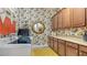 Well-appointed laundry room with cabinetry, modern appliances, and stylish wallpaper at 5715 Inspiration Ter, Bradenton, FL 34210