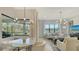 Inviting living room featuring large windows with a water view, and neutral toned furniture beneath a modern light fixture at 5715 Inspiration Ter, Bradenton, FL 34210