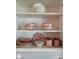 Neatly organized cabinet showcasing a collection of stylish dishes and mugs, perfect for a well-stocked kitchen at 5888 17Th W St # C23, Bradenton, FL 34207