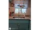 Well-lit kitchen sink area with granite countertops and blue cabinets, creating a functional and stylish space at 5888 17Th W St # C23, Bradenton, FL 34207