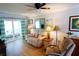 Living room features a reclining sofa, lamps, decor, and sliding door to sun room at 5888 17Th W St # C23, Bradenton, FL 34207