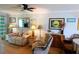 Living room features a reclining sofa, lamps, decor, and sliding door to sun room at 5888 17Th W St # C23, Bradenton, FL 34207