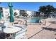 Community pool featuring lounge chairs and tables with umbrellas for residents' enjoyment and relaxation at 5888 17Th W St # C23, Bradenton, FL 34207