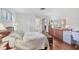Bright bedroom featuring hardwood floors, a dresser, and white shuttered closet doors at 6414 Sun Eagle Ln, Bradenton, FL 34210