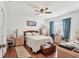 Comfortable bedroom with wooden furniture, a ceiling fan, and a window with blue curtains at 6414 Sun Eagle Ln, Bradenton, FL 34210
