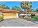 Charming house featuring a two-car garage, red tile roof, and well-maintained landscaping with palm trees at 6414 Sun Eagle Ln, Bradenton, FL 34210