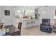 Bright kitchen with an island, pendant lights, and white cabinetry, complemented by a nearby sitting area at 6414 Sun Eagle Ln, Bradenton, FL 34210