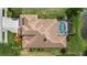 Aerial view of roof, pool with screened enclosure, and manicured landscaping at 6532 Coopers Hawk Ct, Lakewood Ranch, FL 34202